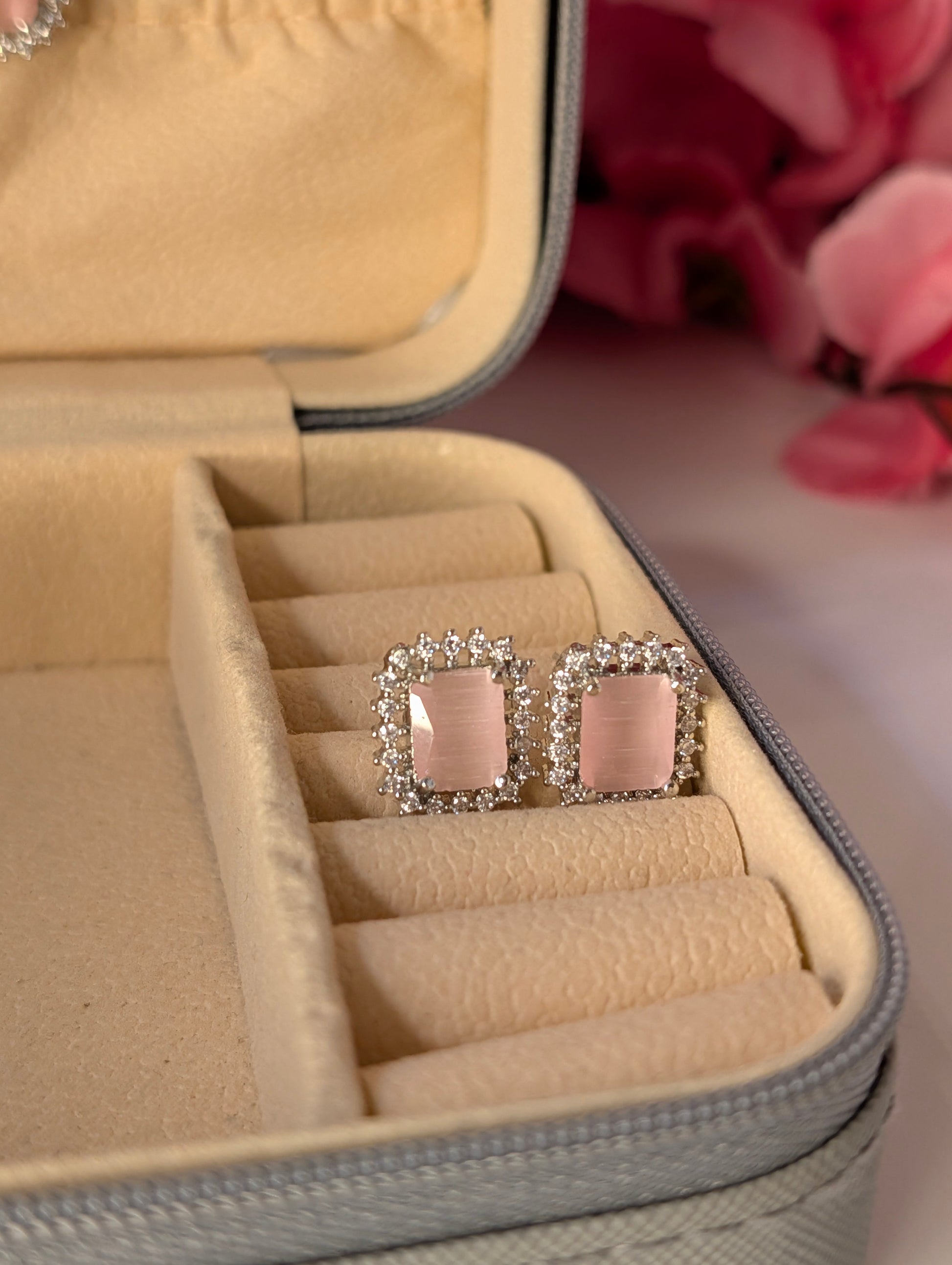 Pink square earrings with silver frame in a jewelry box