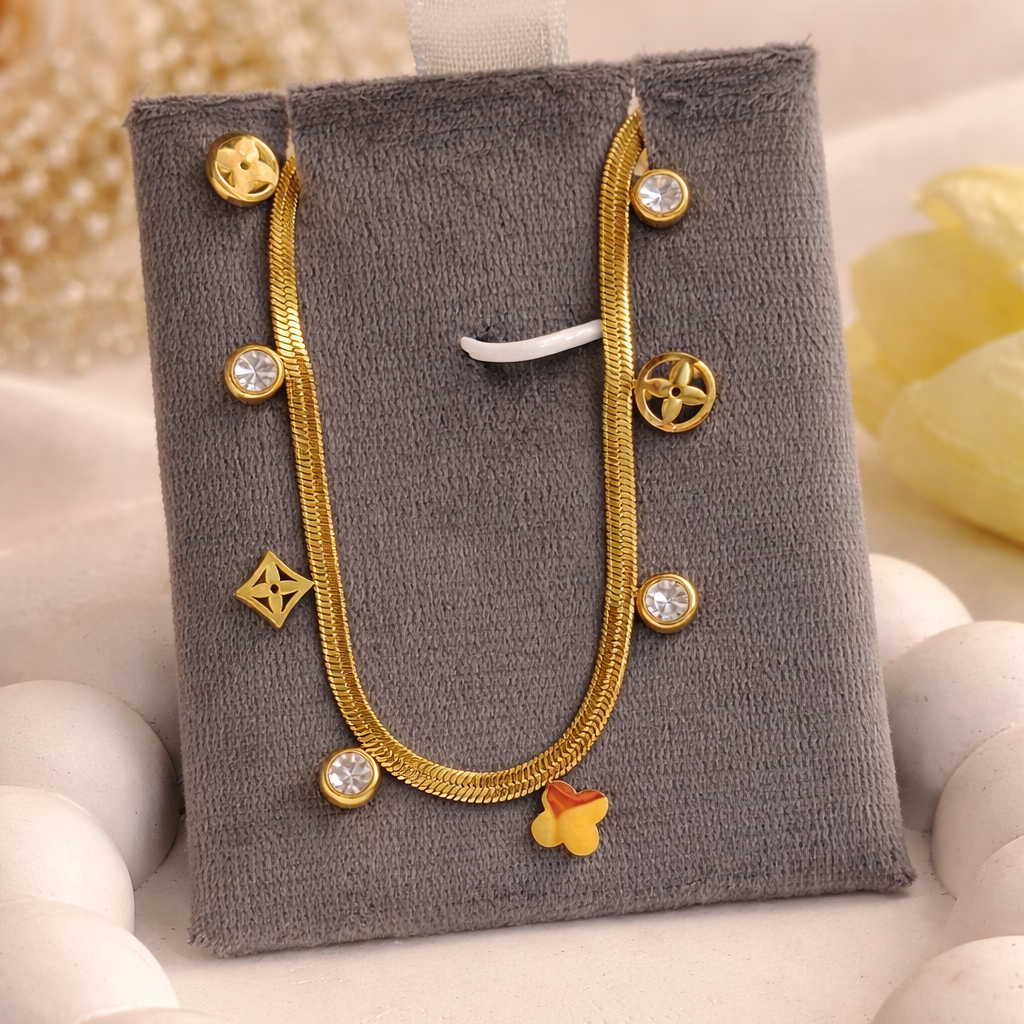 Gold necklace with decorative elements on a gray jewelry display