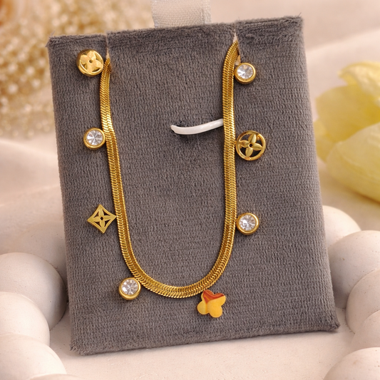 Gold necklace with decorative elements on a gray jewelry display