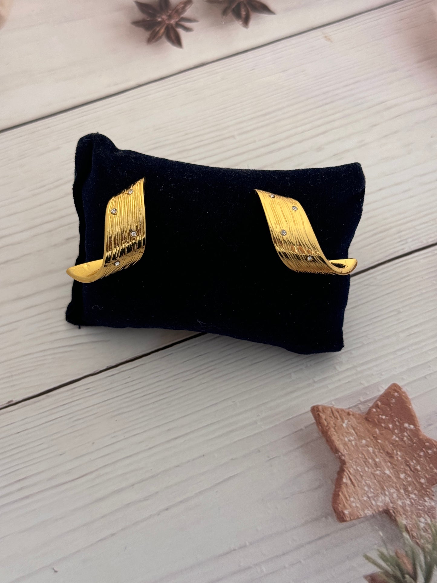 Black pouch with gold accents on a light wooden surface