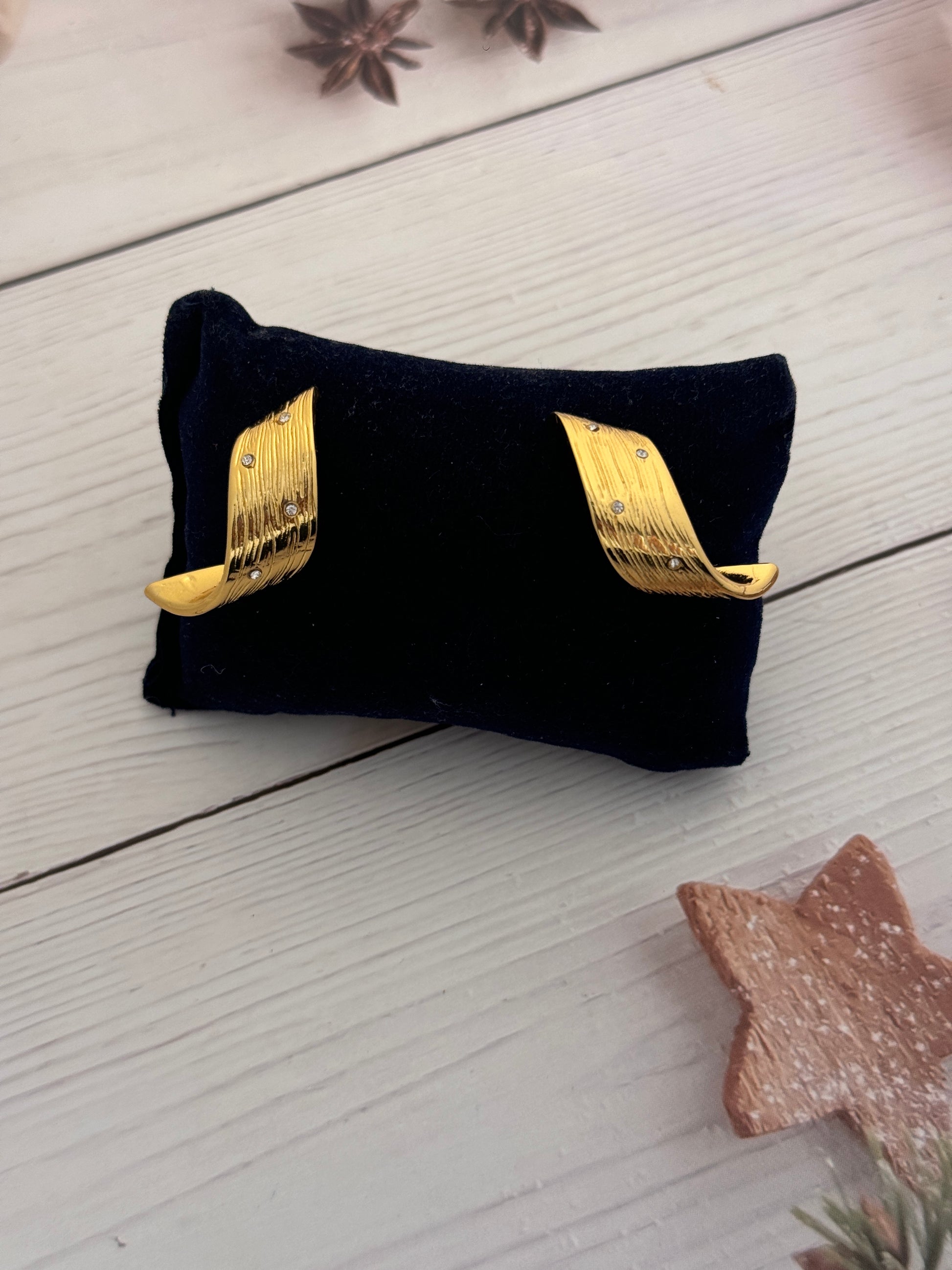 Black pouch with gold accents on a light wooden surface